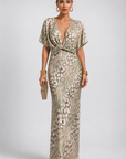 Woman wearing a patterned evening gown on a plain background